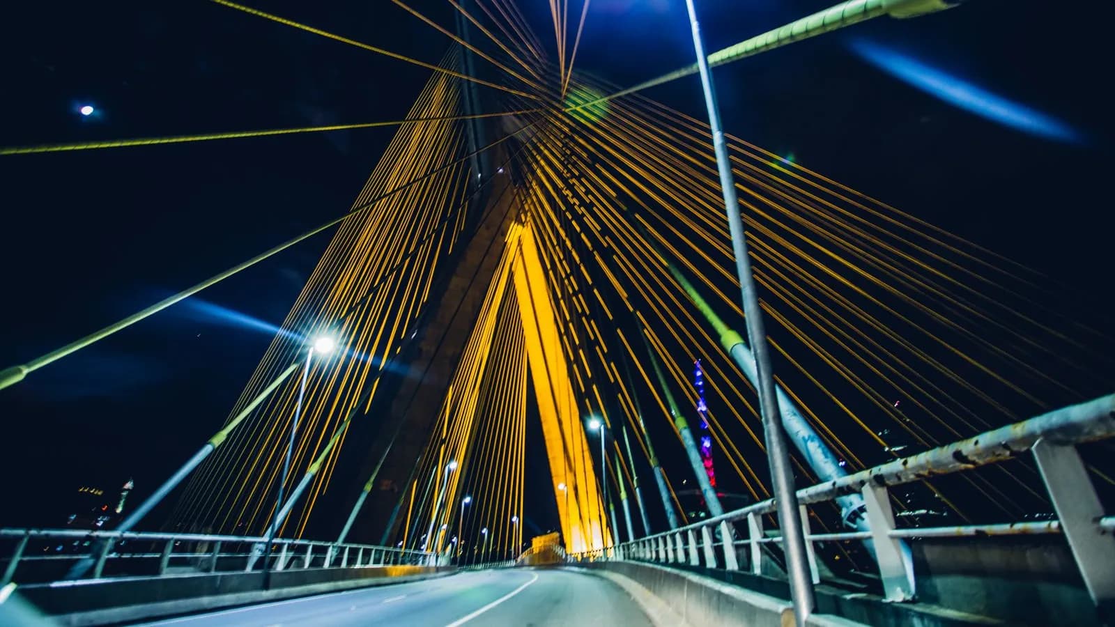 Illuminated cable-stayed bridge glowing against the night sky, a bridge connecting ABM to buyers