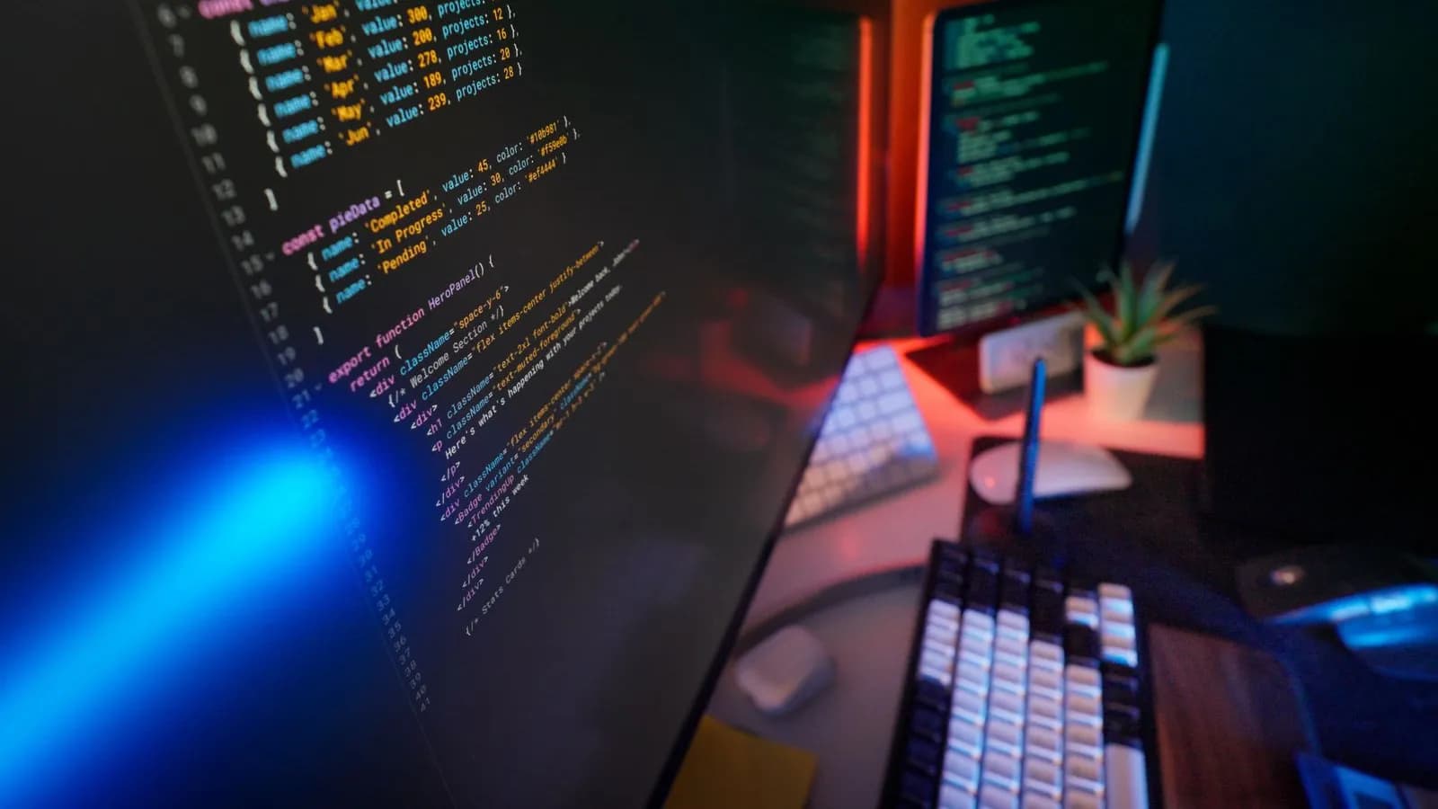 Dashboard code glowing across multiple monitors in a dark developer workspace, building connected go-to-market systems