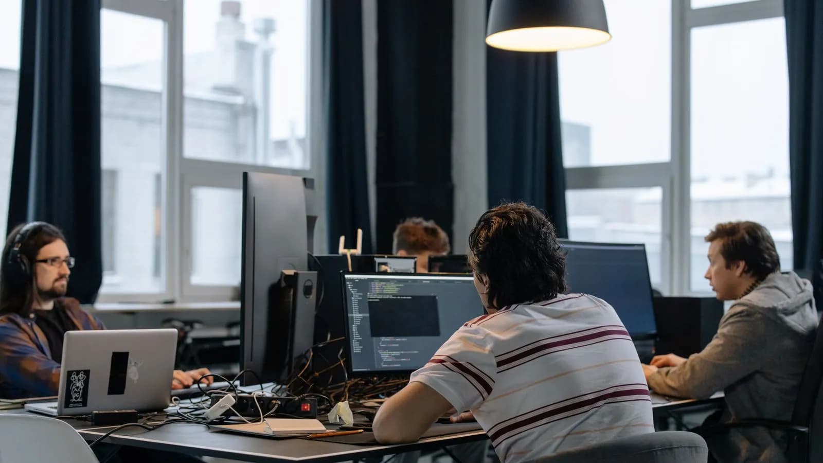 Software developers collaborating on code at a workstation