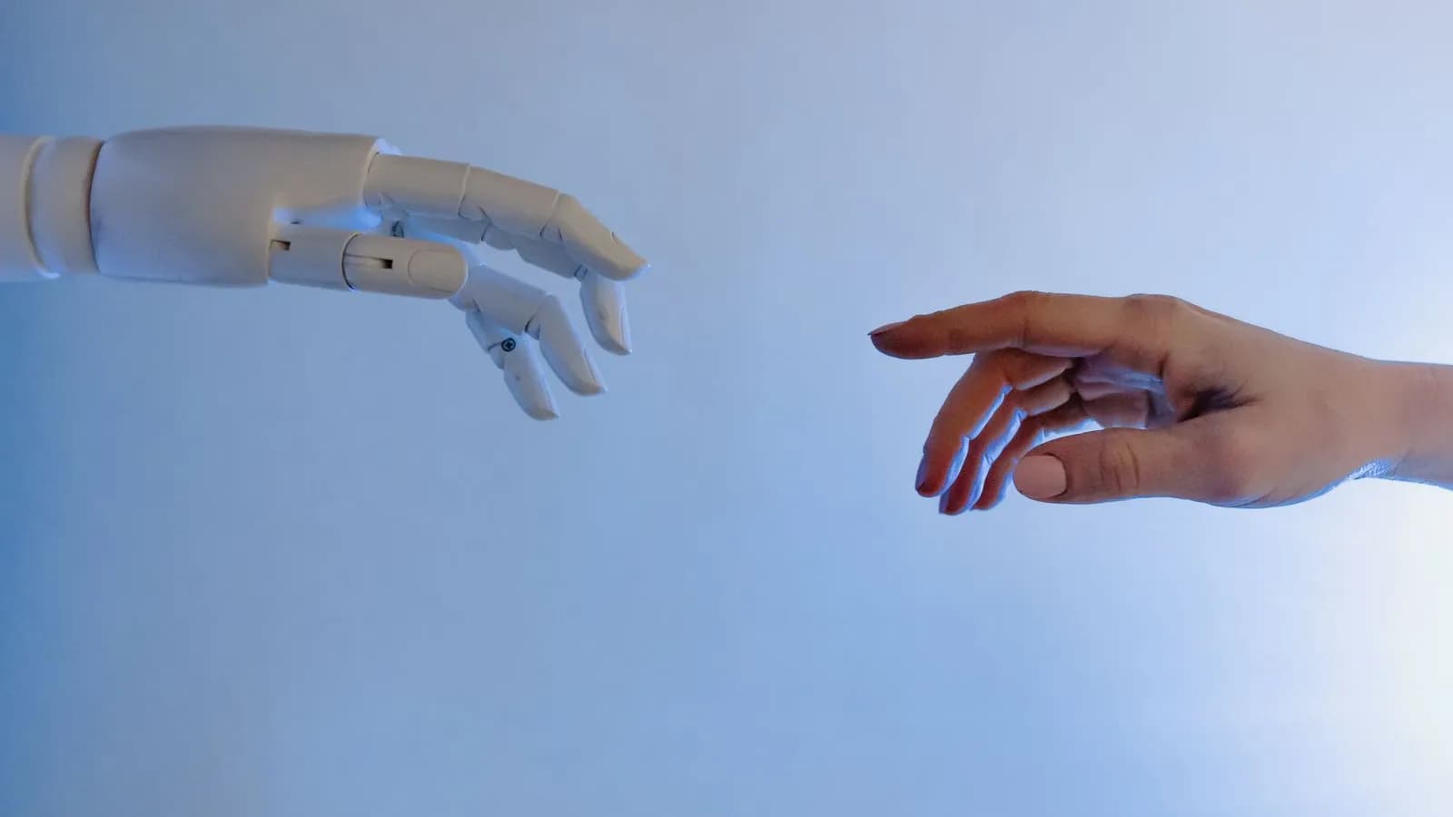 Robotic hand and human hand reaching toward each other, symbolizing custom AI built around a business
