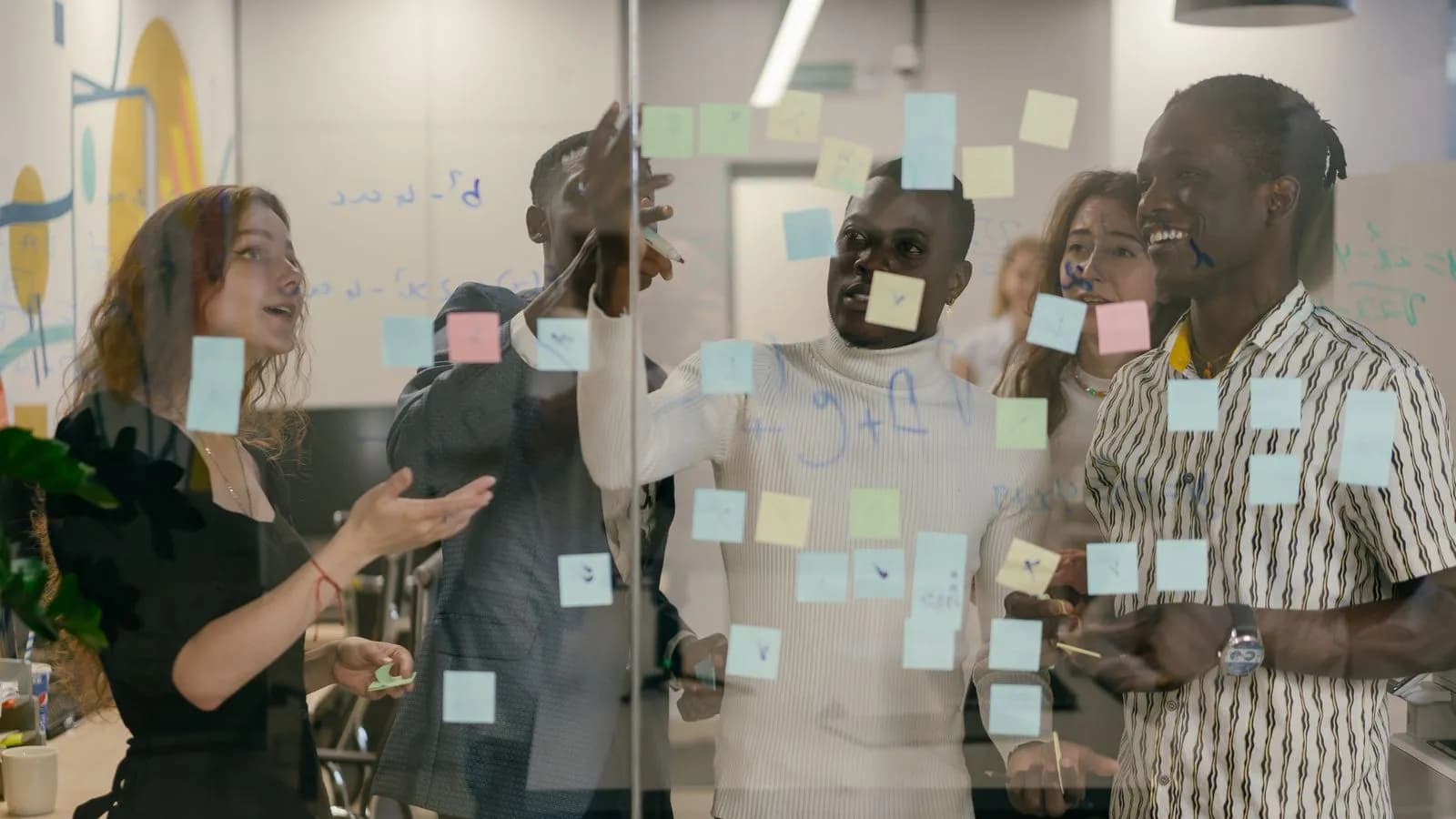 A B2B revenue team mapping accounts and buying committees with sticky notes on a glass wall